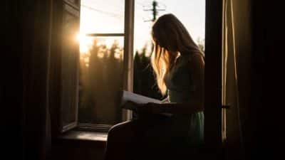 Girl reading at window