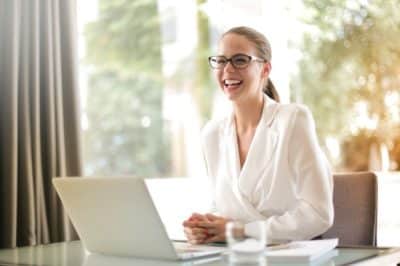 Woman sitting at laptop laughing