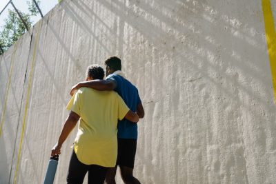 Men walking with their arms around each other