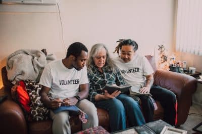 Volunteers with elderly woman