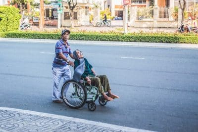 Man pushing woman in wheelchair